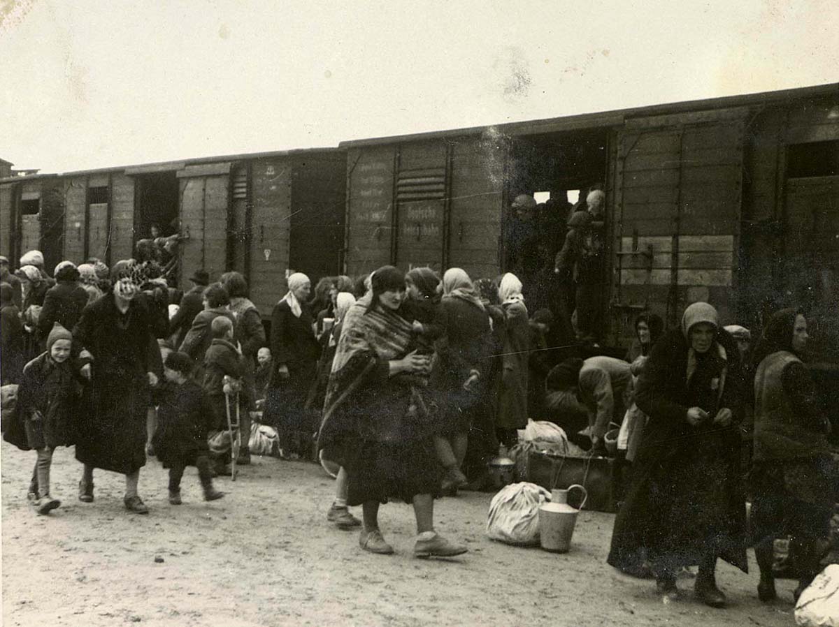 Frauen und Kinder auf dem Ankunftsbahnsteig in Birkenau, der als „Rampe“ bekannt ist. Die Juden wurden aus den Deportationszügen auf die Rampe geholt, wo sie einem Selektionsprozess unterzogen wurden – die meisten wurden sofort in den Tod  geschickt, andere zur Zwangsarbeit eingesetzt