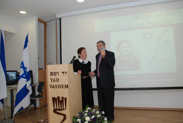 Mrs. Malka Asaria Helfgott passes the military identification tag of her husband Rabbi Dr. Zvi Asaria-Herman Helfgott to Avner Shalev, Chairman of the Yad Vashem Directorate