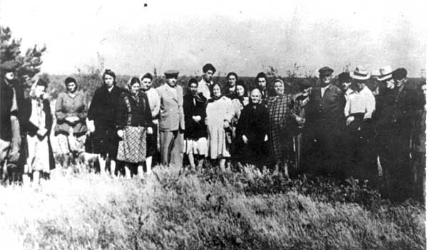 ניצולי שואה מתאספים סביב קבר אחים בדובנו, 1945
