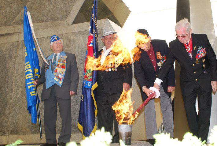 Roman Yagel, President of the Organization of Wounded Partisans and Soldiers of WWII, lights the memorial torch
