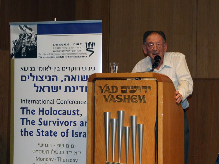 פרופ' יהודה באואר, יועץ אקדמי של יד ושם, נושא את הרצאת הפתיחה המרכזית במושב הפתיחה של הכנס, שכותרתה - "האם מדינת ישראל קמה בשל השואה?"