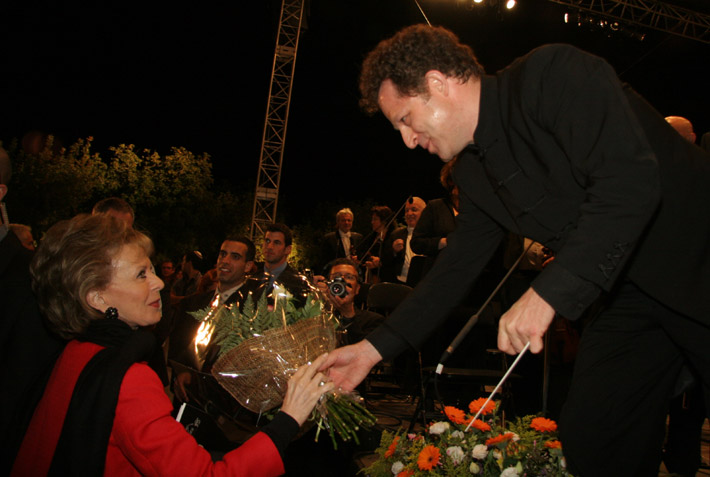 המנצח ג'ון אקסלרוד מעניק זר פרחים לגב' לילי ספרא לאחר ההופעה