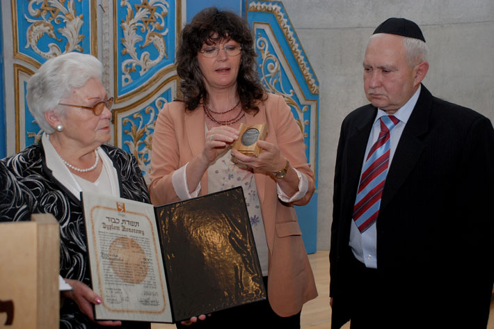 Janina Woloszczuk, daughter of Wojciech Woloszczuk,  receives the medal and certificate of honor