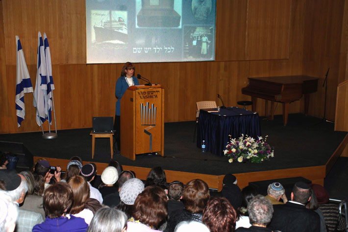 Ms. Debby Spero (daughter of Rabbi Schonfeld) speaks during the event