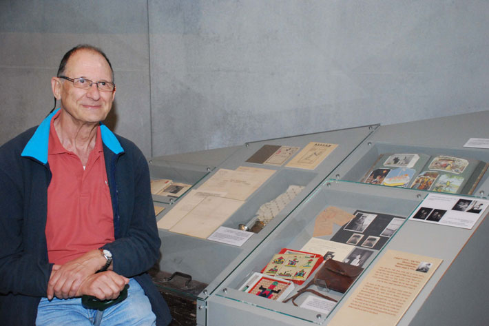 Mr. Henry Foner next to the postcards that he received from his father after arriving in the UK with the Kindertransport
