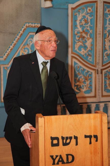 מר אורי חנוך, יו&quot;ר העמותה להצבת יד לזכר קורבנות מחנות הריכוז לנדסברג-קאופרינג-דכאו, מנחה את הטקס בבית הכנסת