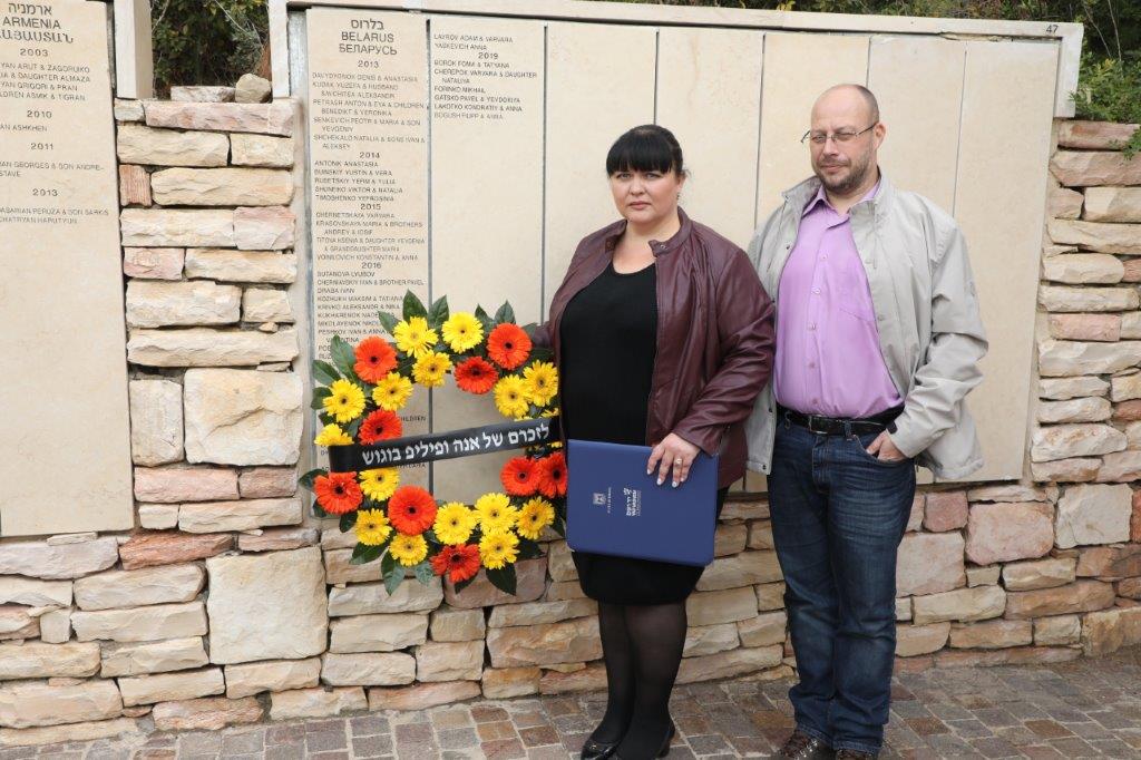 Elana Kimbarovskaia and her husband laying a wreath by the Wall of Honor bearing the names of her grandparents honored as Righteous Among the Nations