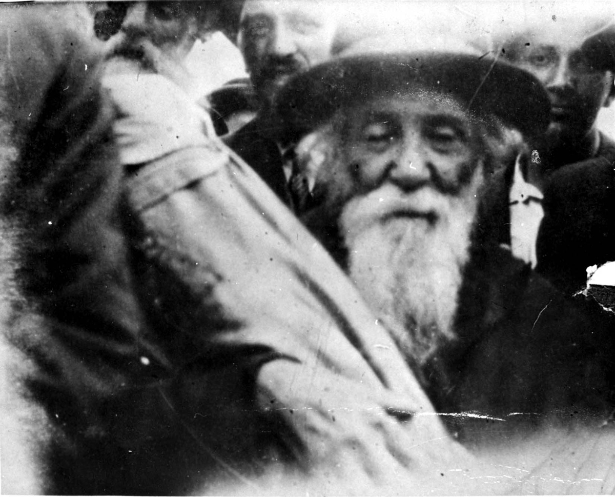 El rabino de la ciudad llevando el rollo de la Torá cuando se dirige a un tren para ser deportado, Iasi, Rumania, junio de 1941