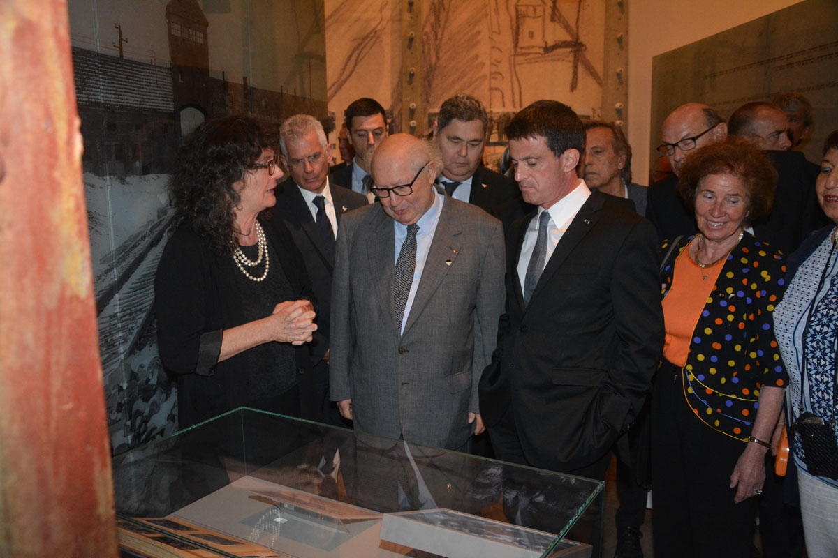 Manuel Valls, entouré par Serge et Beate Klarsfeld, devant l'Album d'Auschwitz exposé au Musée d'Histoire de la Shoah. 