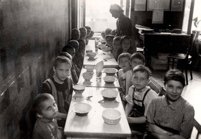 אישה מגישה אוכל לילדים בגטו ורשה