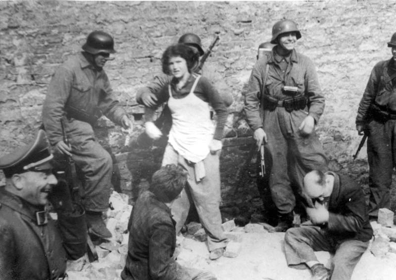 פלסים (sappers) של הצבא הגרמני, אשר הופקדו על פיצוח בונקרים, עם יהודים שנשלפו על ידם מתוך בונקר תת-קרקעי, כנראה 8/5/1943