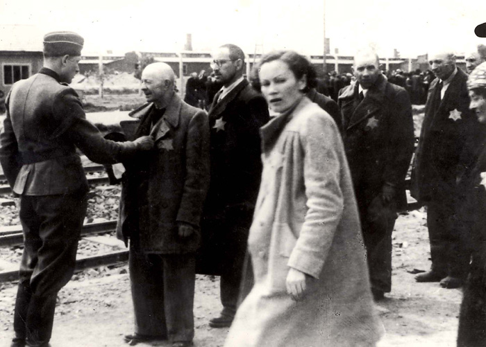 Birkenau, Poland, Geiza Lajtos passing next to a selection of Jewish men by an SS man