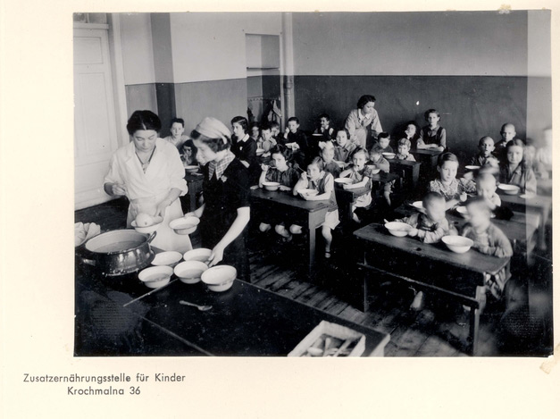 Warsaw, Poland, Women distributi​ng food to children in a public soup kitchen in the ghetto