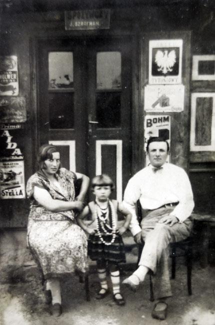 יודקה וצילה שרפמן עם בתם חנה בפתח המכולת המשפחתית, 1930