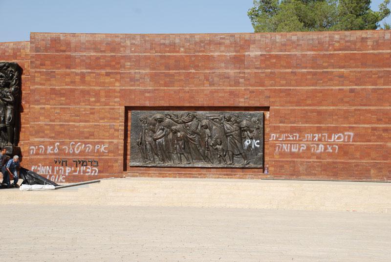 Hateful graffiti in the open campus of Yad Vashem, scrawled across the walls of the Warsaw Ghetto Square monument