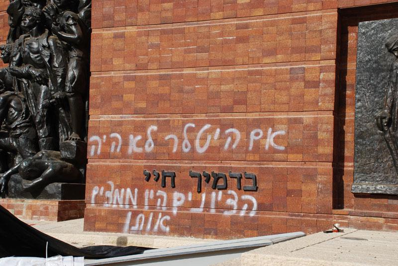 Hateful graffiti in the open campus of Yad Vashem, scrawled across the walls of the Warsaw Ghetto Square monument