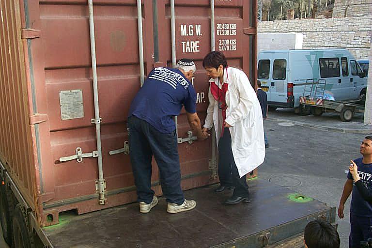 Haviva Peled-Carmeli, Director of the Artifacts Department at Yad Vashem breaking the seal of a container packed with Torah Arks from Romania. December 1999