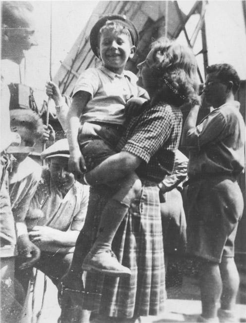 Children from Buchenwald on the ship to the Land of Israel. Lolek is held by the counselor