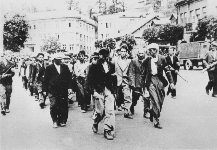 חברי המיליציה הליטאית מובילים יהודים ל"פורט השביעי" בקובנה, ליטא, 25 ביוני 1941
