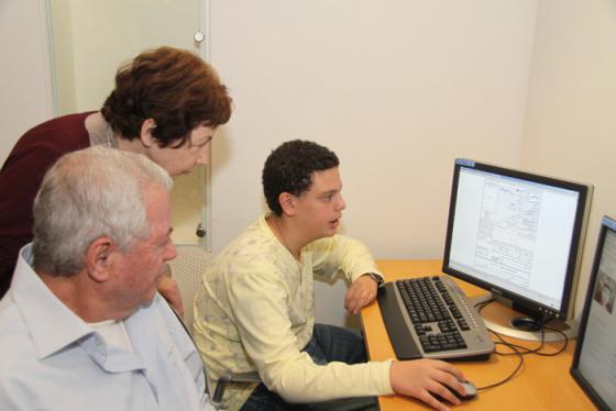 Cousins Liora Tamir and Aryeh Shikler with Aryeh's grandson Elad Ganot search Yad Vashem's Central Database of Shoah Victims' Names