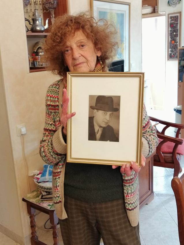 Jacqueline Schochat Rebibo avec une photo encadrée de son père, à son domicile de Jérusalem, février 2022