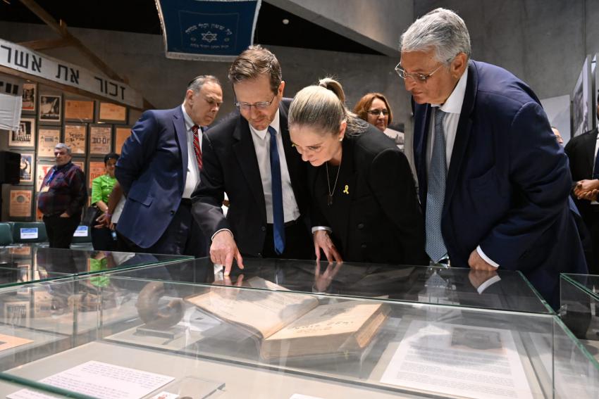 Israel's President Isaac Herzog, his wife, Michal, and brother Yoel, the Head of Swiss Friends of Yad Vashem, looking at the Holocaust-era artifact, a volume of the Talmud, that belonged to their grandfather