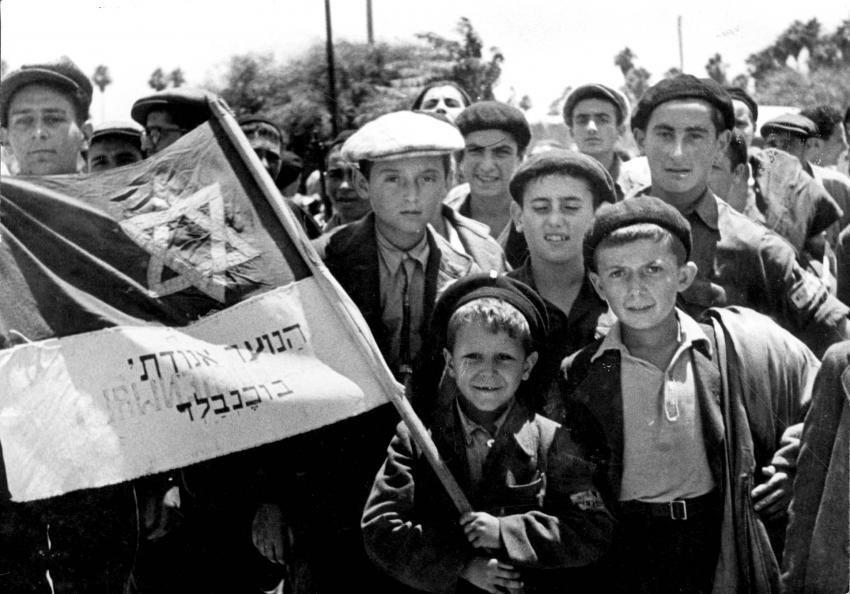 נפתלי לביא (משמאל) בקרב קבוצת ילדים ובני נוער יהודים במחנה העקורים בבוכנוולד. נושא הדגל הוא אחיו הצעיר, ישראל מאיר לאו. 