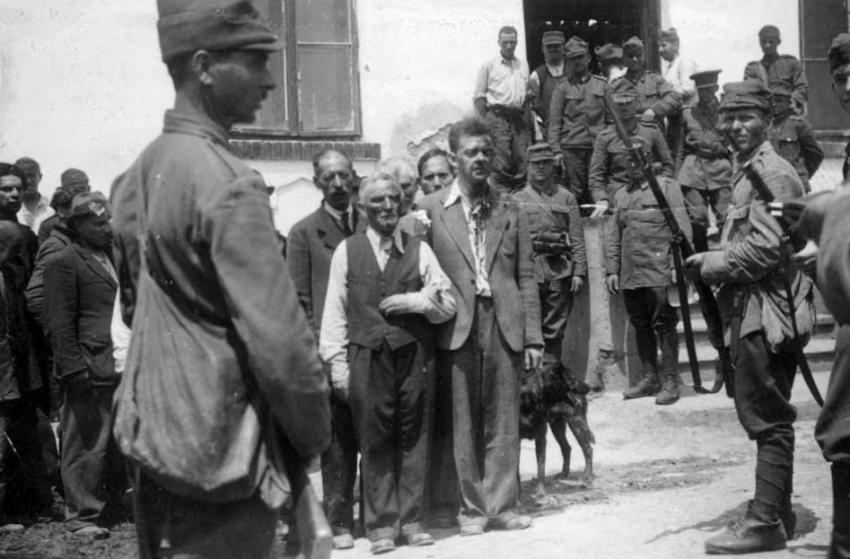ראשי הקהילה היהודית ביאסי מוכים ומושפלים תחת שמירה של חיילים רומנים בפתח מפקדת המשטרה, 28-29 ביוני 1941.