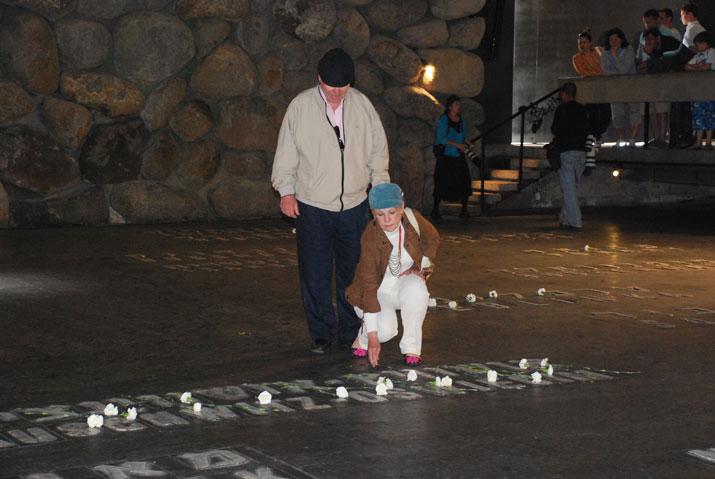 Visitors to Yad Vashem place a flower in the Hall of Remembrance after reciting the names of loved ones
