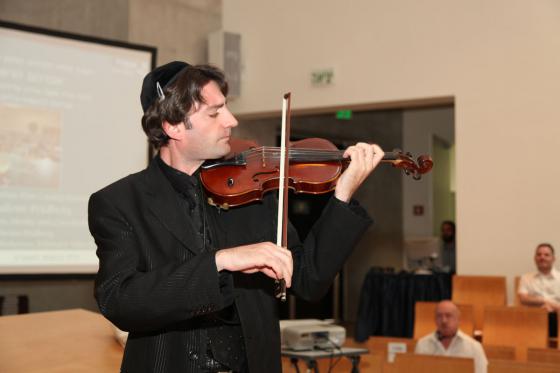 סניאס אל קרויטר, כנר, מנגן במהלך טקס ההוקרה בבית הכנסת ביד ושם