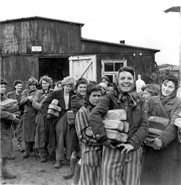 Grupo de sobrevivientes sujetando pan, Bergen-Belsen, Alemania