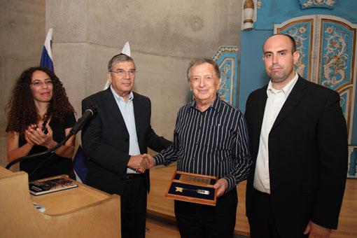 Avraham Harshalom receives a symbolic present “the Yad Vashem Key” from Avner Shalev, Chairman of the Yad Vashem Directorate. Next to them: Liat Benhabib, Director of the Visual Center at Yad Vashem and Yaniv Oren