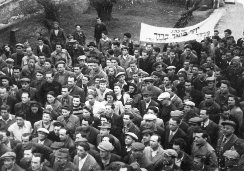 Reception in honor of Rabbi Yitzhak Herzog at the Santa Marina di Leuca camp after the war. The words “May Your Coming Be Blessed” are inscribed on the sign carried by members of Beitar’s Kibbutz “Atid”.