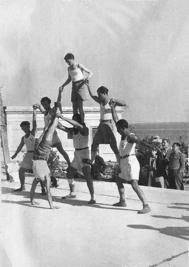 Jóvenes pioneros en el entrenamiento de gimnasia en el campo de refugiados de Marina di Leuca, Italia