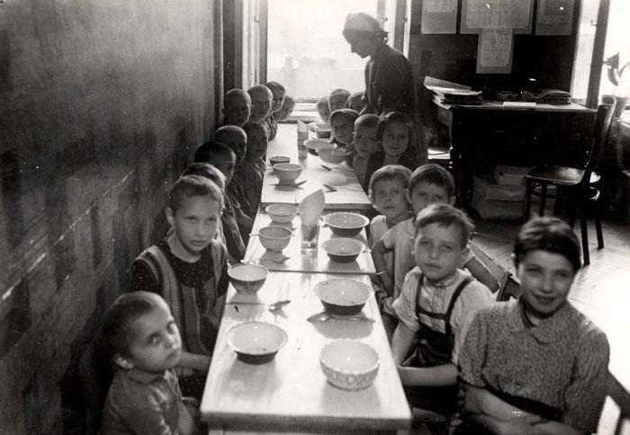 Warsaw, Poland, A woman serving food to children in a public children on 11 Karmelicka Street