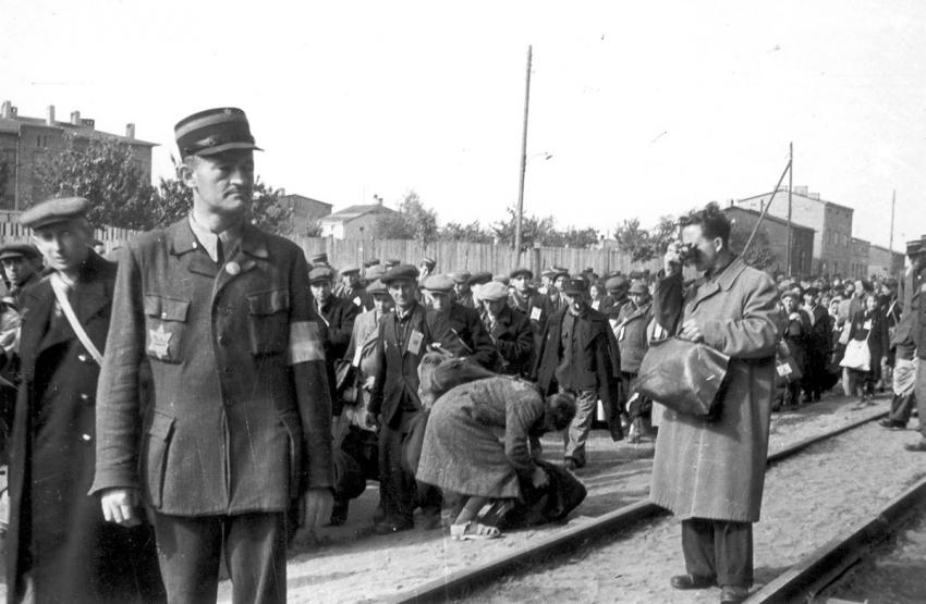 Mendel Grossman photographing a deportation of Jews from the Lodz ghetto. The photo was taken by Grossman's assistant, Arieh Ben Menachem