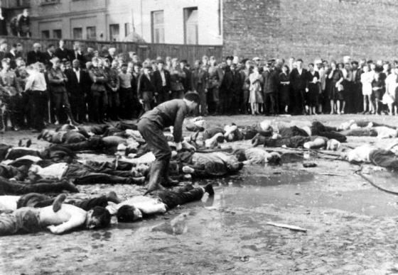 קובנה, ליטא – אנשים מתקהלים לצפות בגוויות של יהודים שנרצחו על ידי ההמון הליטאי, זמן קצר לאחר הכיבוש הגרמני של העיר
