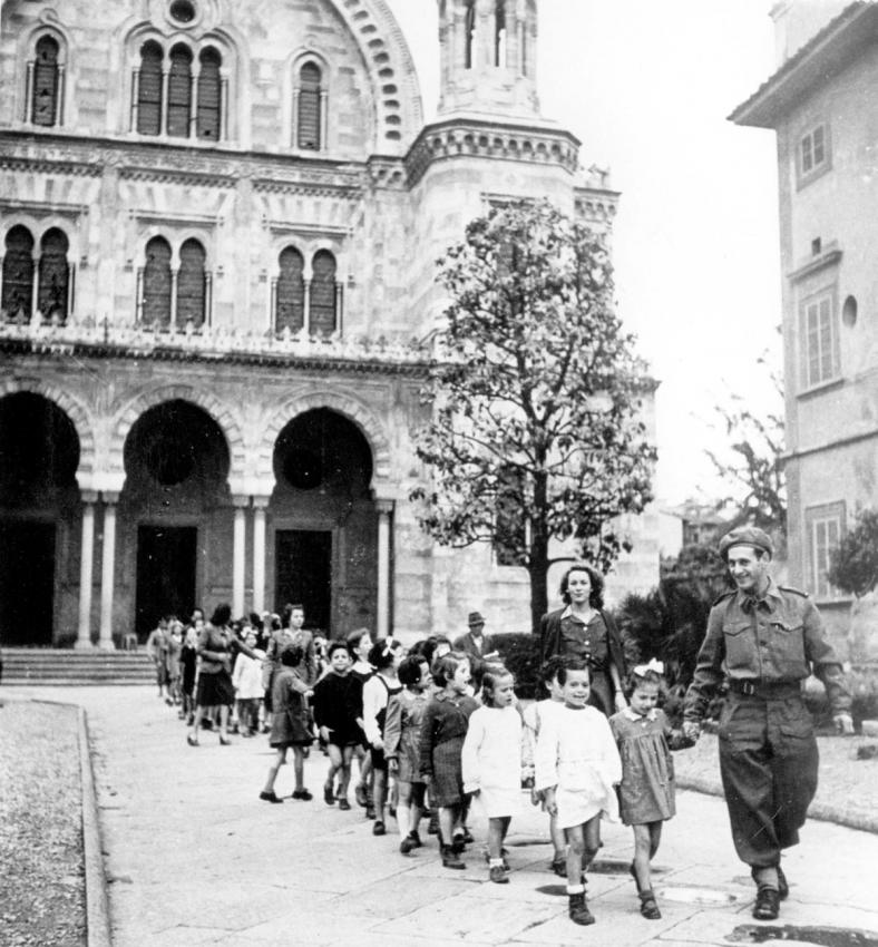A Jewish Brigade soldier escorts children to school in Florence, Italy after the war.