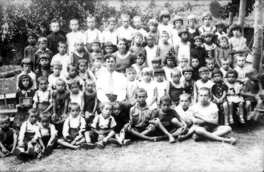 Students at the Jewish elementary school (Yiddishe Folks Shul) at a summer camp, c. 1932. In the center: the Hebrew teacher Fikus. First row, sitting farthest right – Zvi Katzenelson; fourth from right – his friend Moshe Rabinovitz