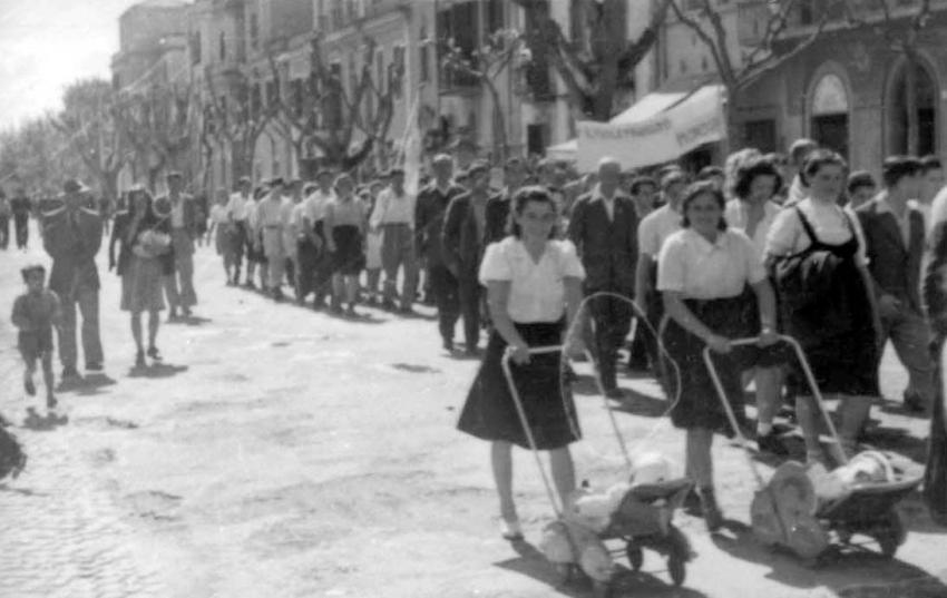 Parade at the DP camp in Ostia, near Rome, 1946-1947. Pessia Reznik marches with her son Avraham Zeev in a baby carriage in the first row, left
