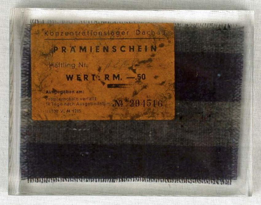 Remnant of prisoner clothing and a cigarette coupon that Leo Goldner took when he was liberated from the Allach-Dachau concentration camp