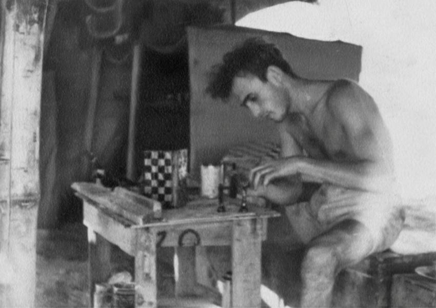 Aryeh Klein carving the chess pieces in front of his tent in the detainment camp in Cyprus.