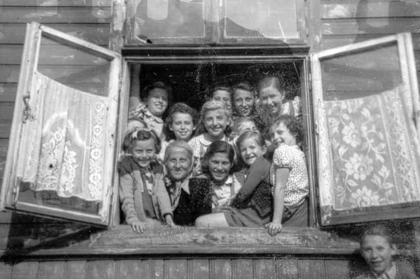 Stella Rein (wearing scarf), teacher and principal of the Rumkowski high school in the Lodz ghetto, with her pupils in Marysin (the agricultural area of the ghetto), 1941-1942.