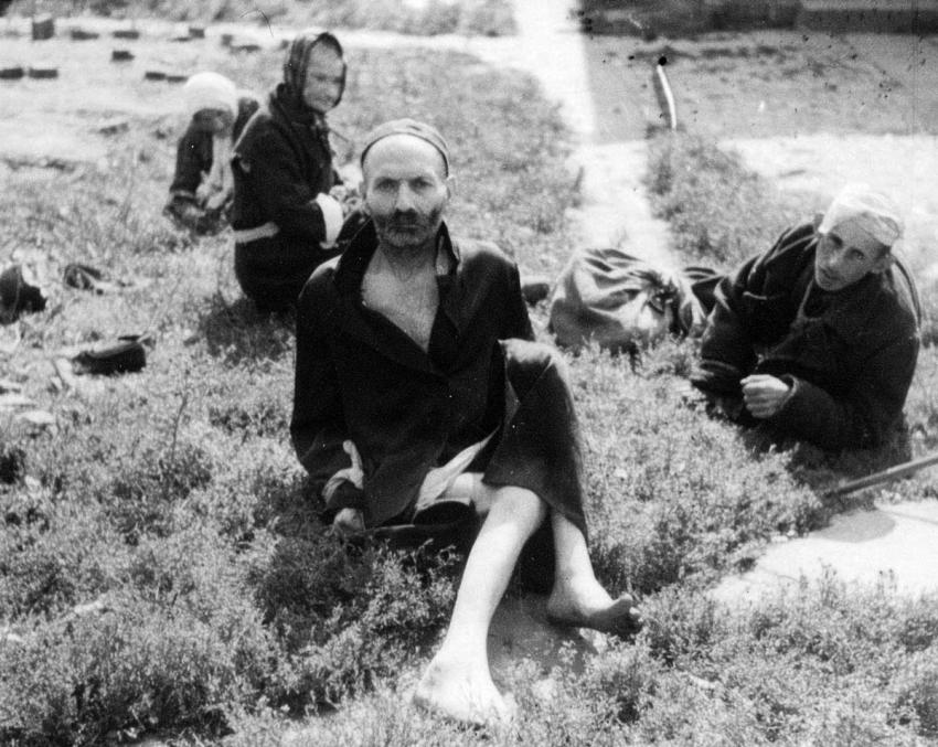 יהודים יושבים בשדה במהלך אחד הגירושים משידלובייץ למחנה המוות טרבלינקה. צולם על ידי גרמני אנונימי בסוף 1942 או תחילת 1943.