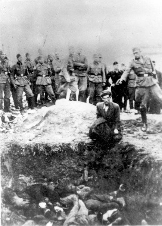 איש ואפן אס-אס יורה ביהודי מעל קבר המוני. ויניצה, אוקראינה, יולי 1941