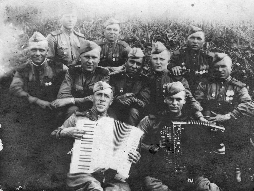 Joseph Katanov in the center of a group of soldiers holding accordions