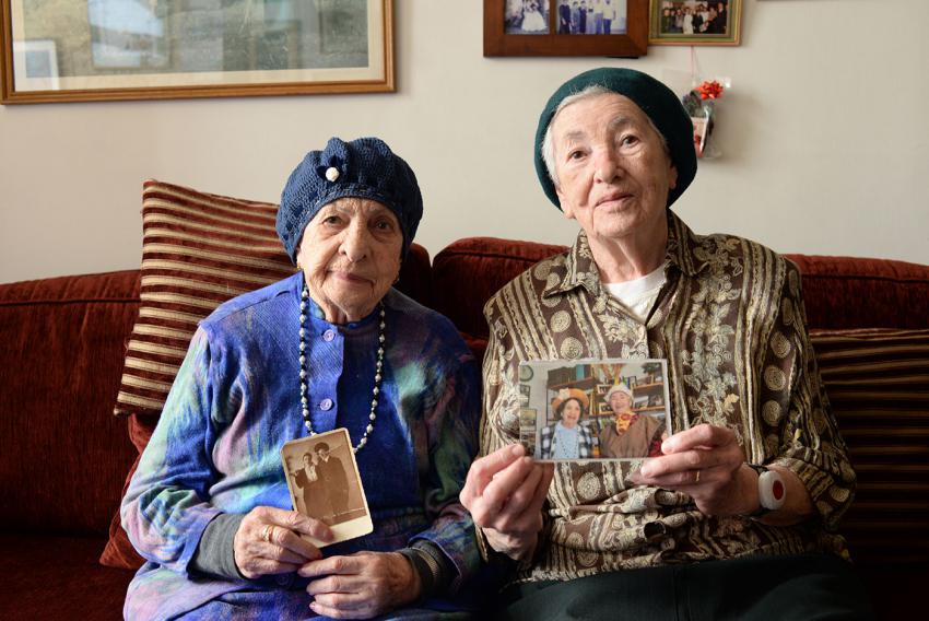 Miriam and Sara Goldstein hold photographs of themselves in costume, during the Holocaust and today
