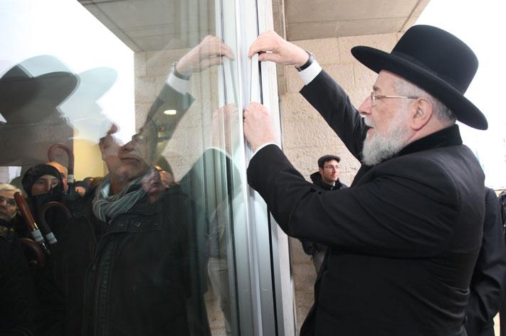 The Chairman of the Yad Vashem Council Rabbi Israel Meir Lau affixing the mezuzah