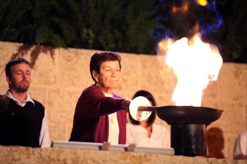 Holocaust survivor Dina Ostrover lights one of the six torches at the ceremony