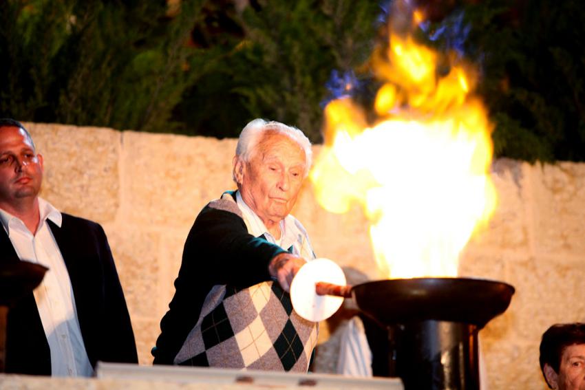 Holocaust survivor Eliezer Eizenschmidt lights one of the six torches at the ceremony